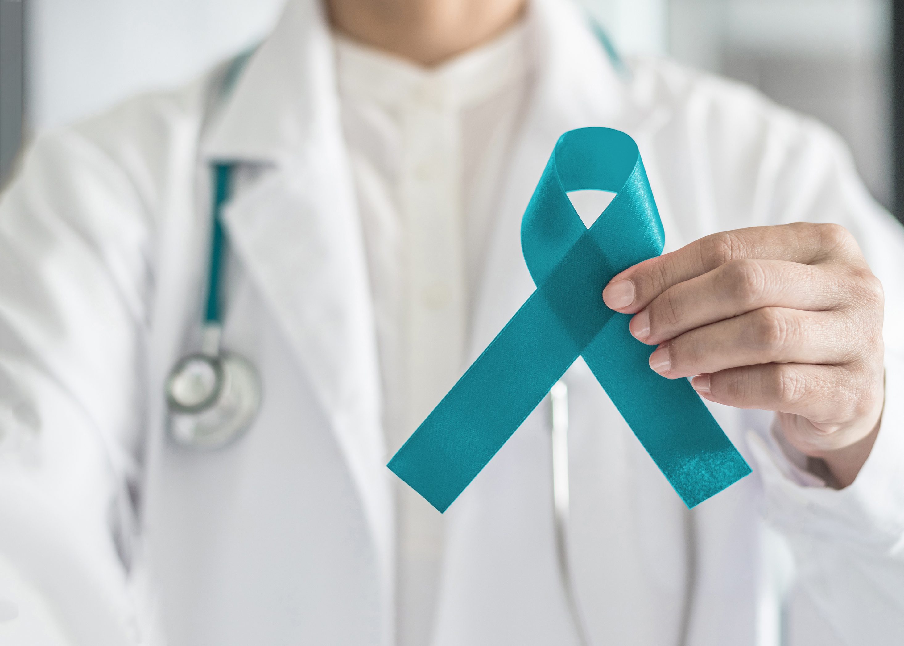 Doctor holding a teal awareness ribbon.